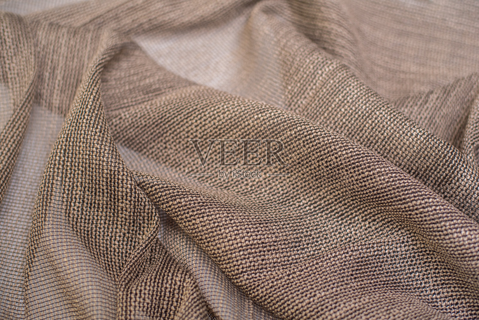 带有棕色网状纹理的窗帘面料。背景为面料褶皱。用于薄纱的面料。照片摄影图片