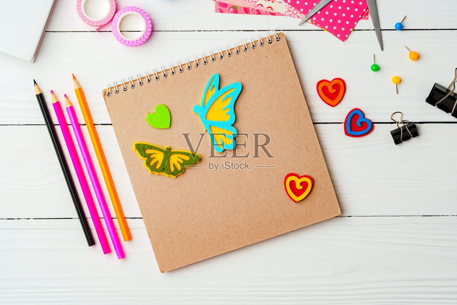 在粗糙的木质表面上，用彩色铅笔、装饰胶带和有趣的形状激发创作灵感照片摄影图片