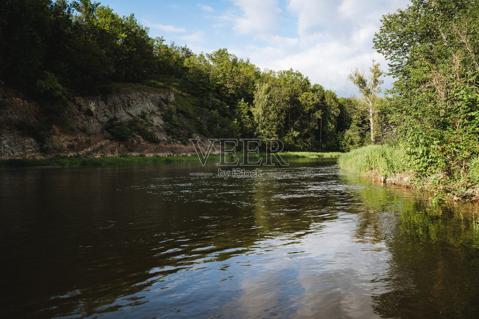 宁静的河流风景，绿树成荫，蓝天清澈，散发出宁静与安详，展现了自然之美与和谐的如画场景。照片摄影图片