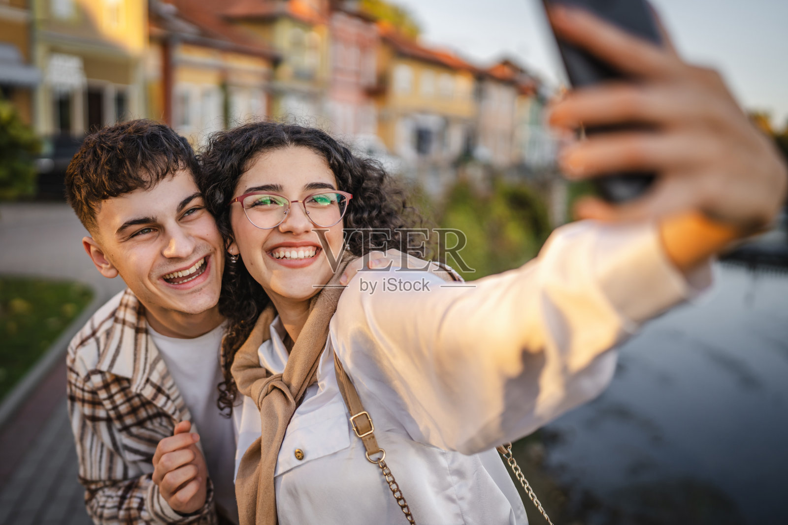 年轻快乐的情侣在河边自拍照片摄影图片