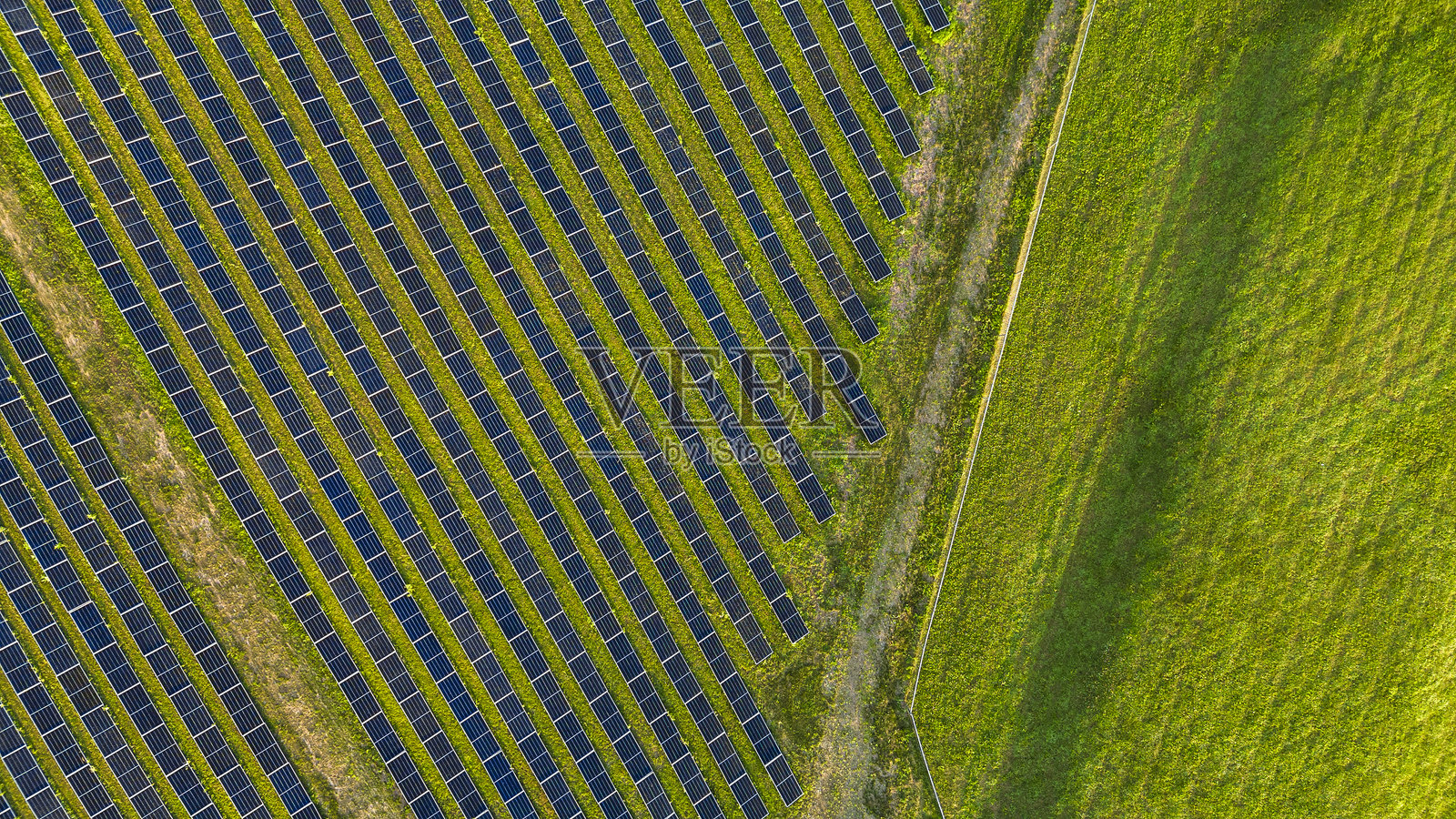 农村田野中的太阳能电池板几何形状。位于宾夕法尼亚州农村的太阳能农场，毗邻绿色牧场。照片摄影图片