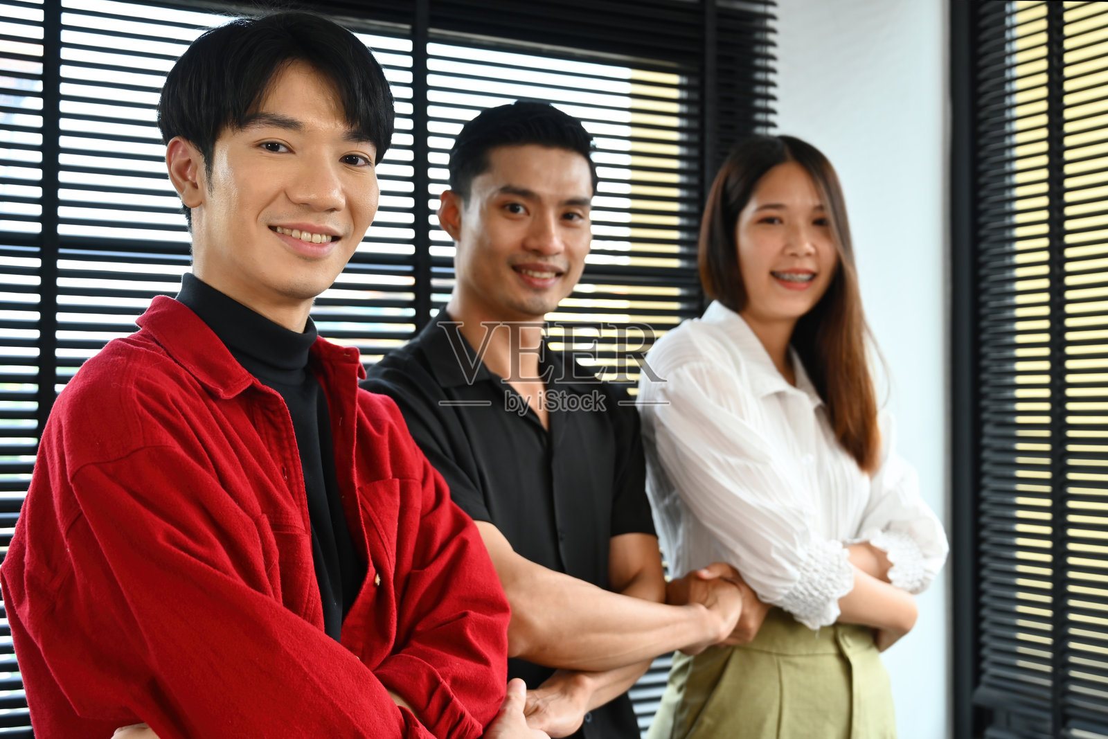 一群不同年龄的创意工作者手牵手，体现合作与团结的概念照片摄影图片