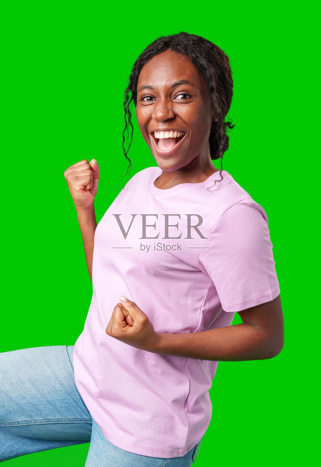 快乐的女性在明亮的绿色背景下用握紧的拳头庆祝成功照片摄影图片