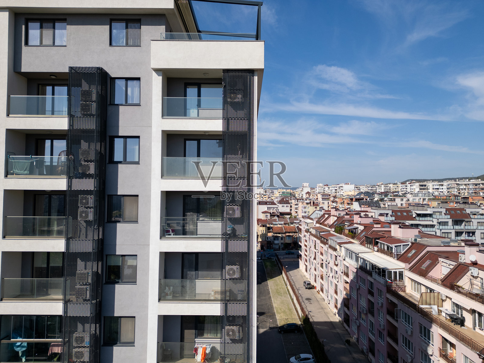 现代住宅高层建筑的鸟瞰图，带有阳台和户外区域。公寓的干净几何设计突显了现代城市生活。使用无人机拍摄。照片摄影图片