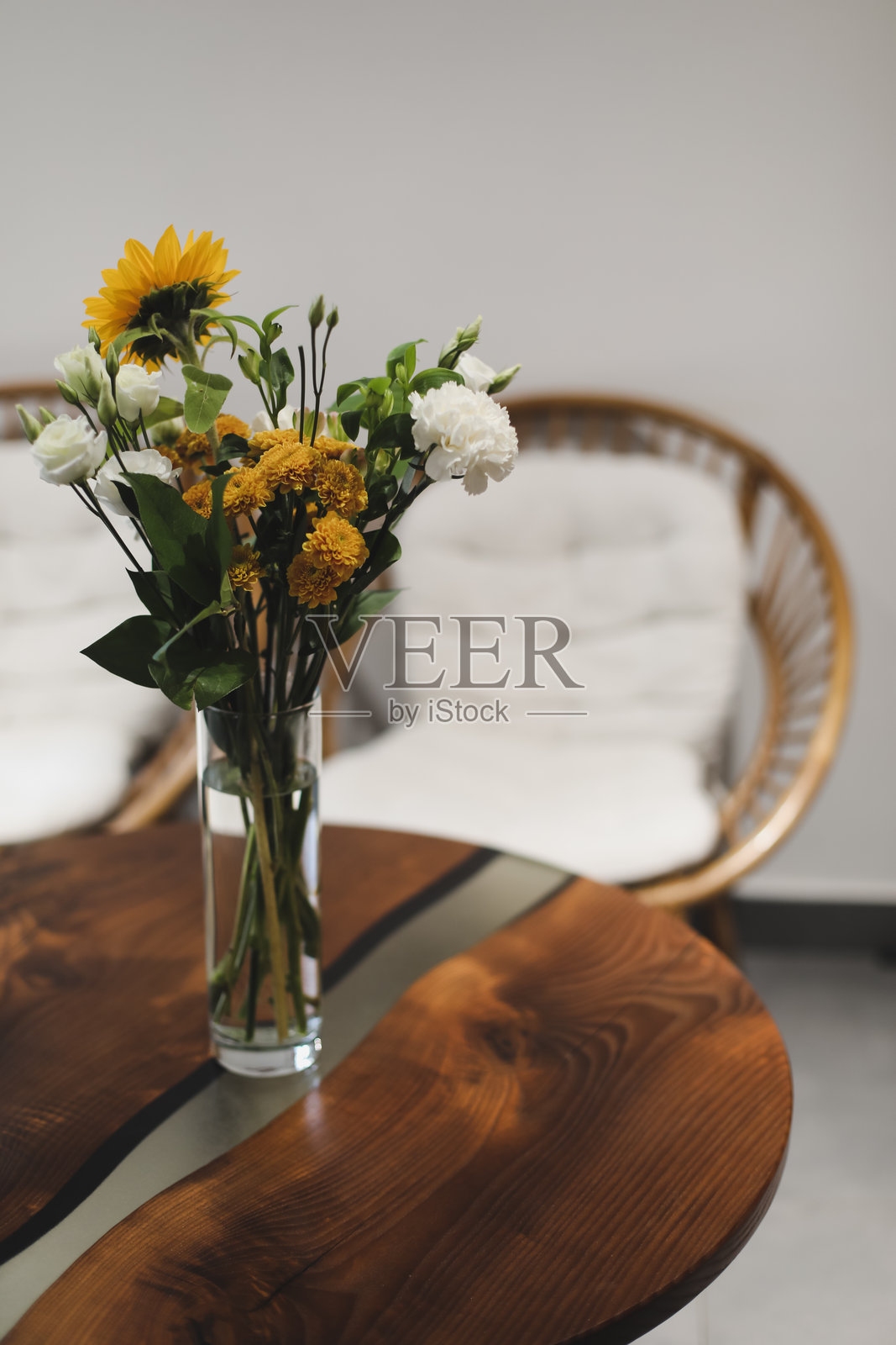 一束美丽的黄色向日葵花在旧的乡村风格木桌上的玻璃花瓶里。秋季温馨的家居装饰。照片摄影图片