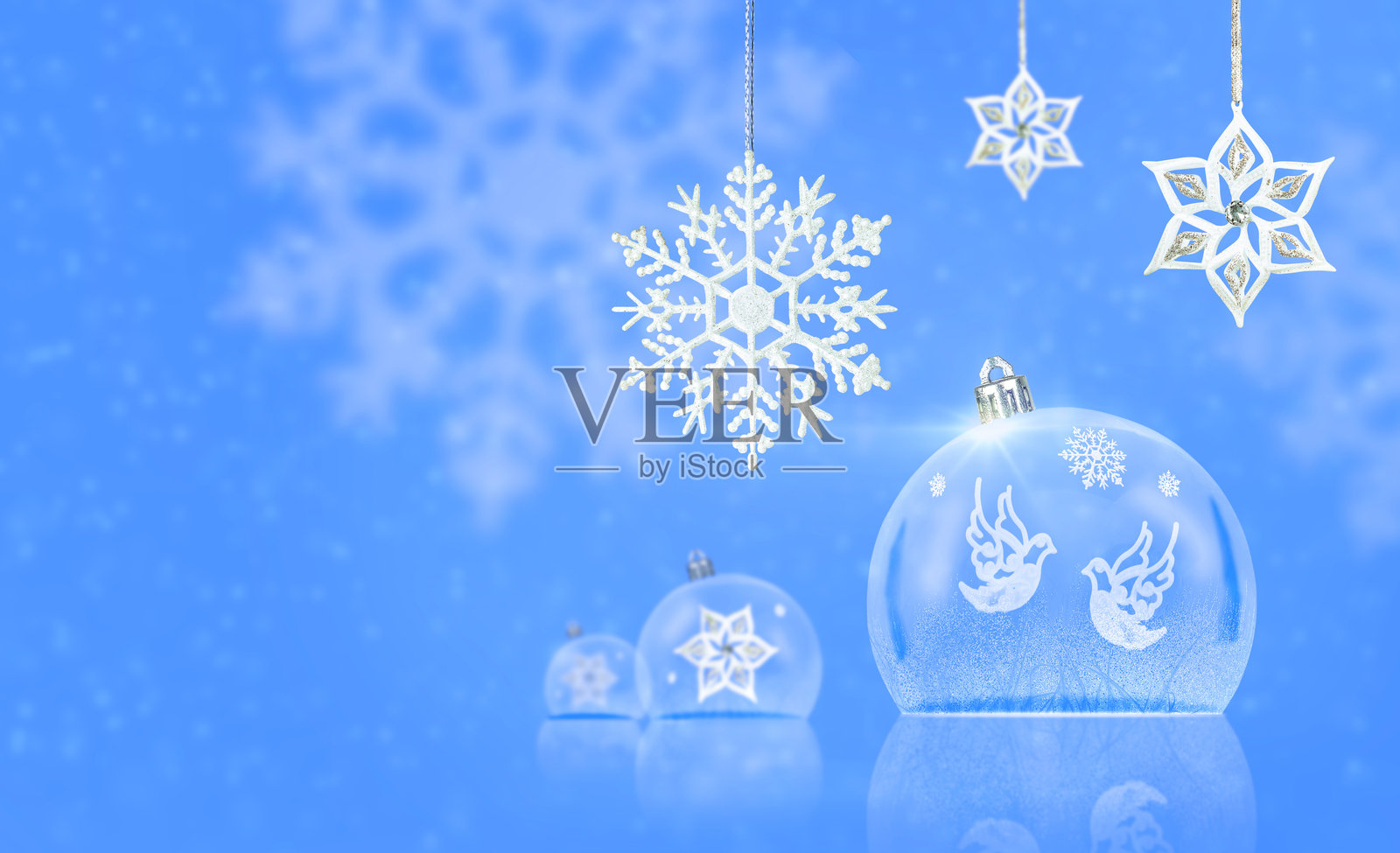 蓝色雪花背景上的透明圣诞球装饰，留白空间照片摄影图片
