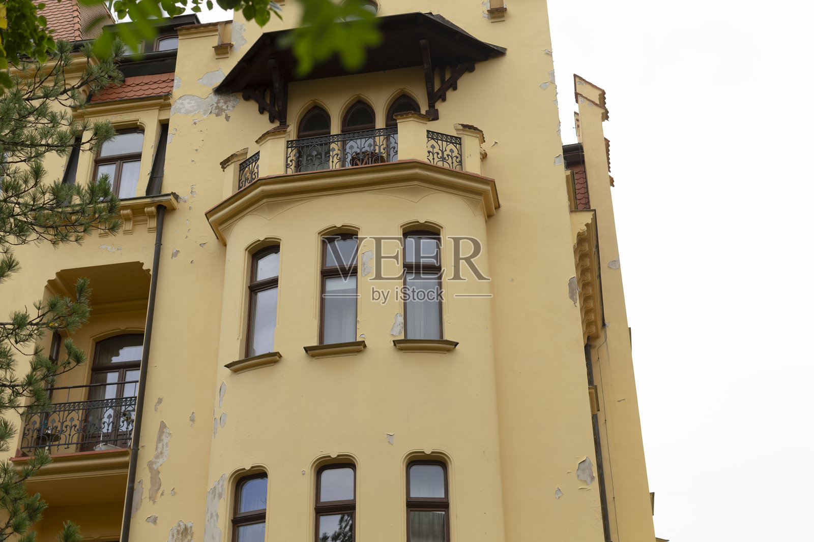 一栋高耸的黄色建筑，顶部设有阳台照片摄影图片