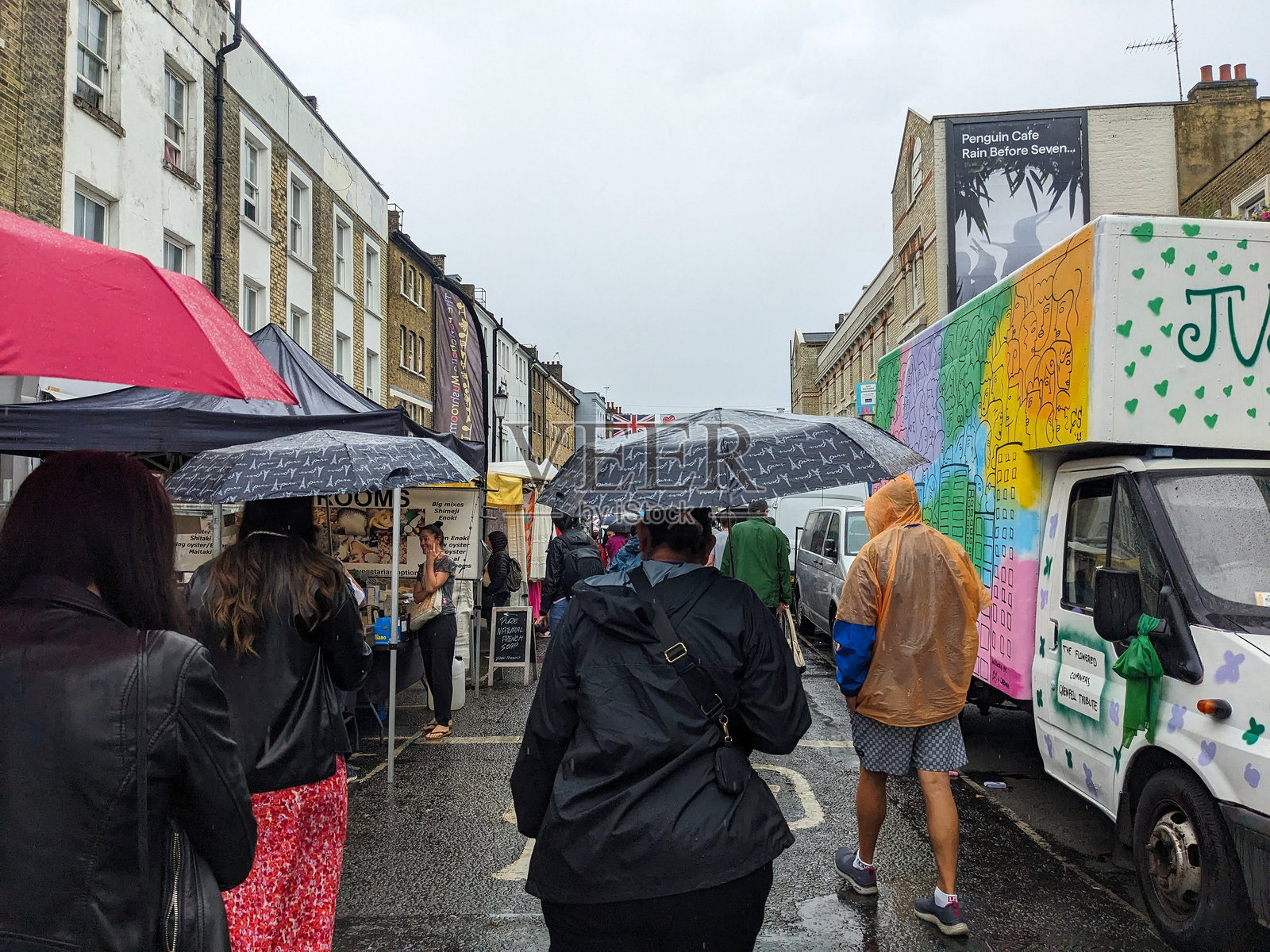 伦敦，英国 - 2023年7月8日：游客在雨中走过波多贝罗路市场照片摄影图片