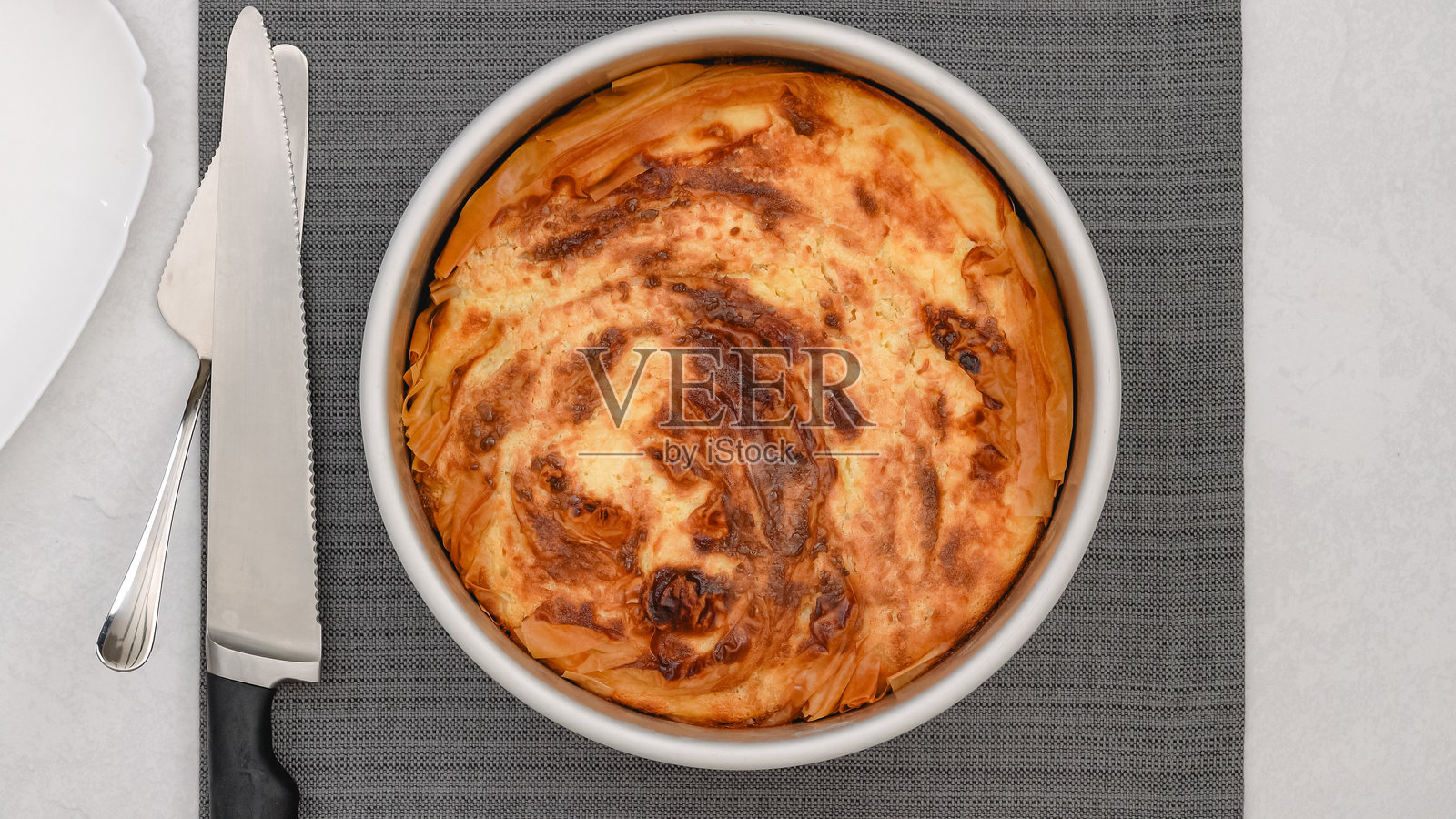 新鲜出炉的酥皮派，金黄色的外壳特写，放在厨房桌上。照片摄影图片