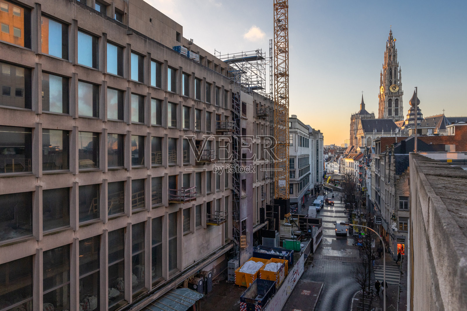 远处有尖顶的城市建筑景观，夕阳映照的天空照片摄影图片