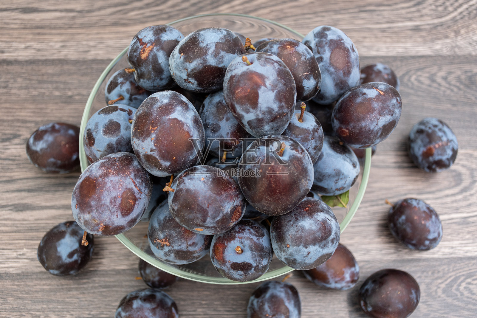 美丽的新鲜李子在玻璃碗中照片摄影图片