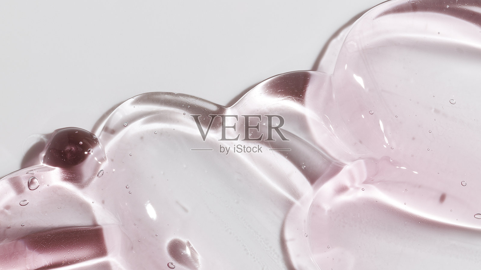 美容凝胶或美容果冻精华的质地背景。粉色透明护肤胶原蛋白产品。照片摄影图片