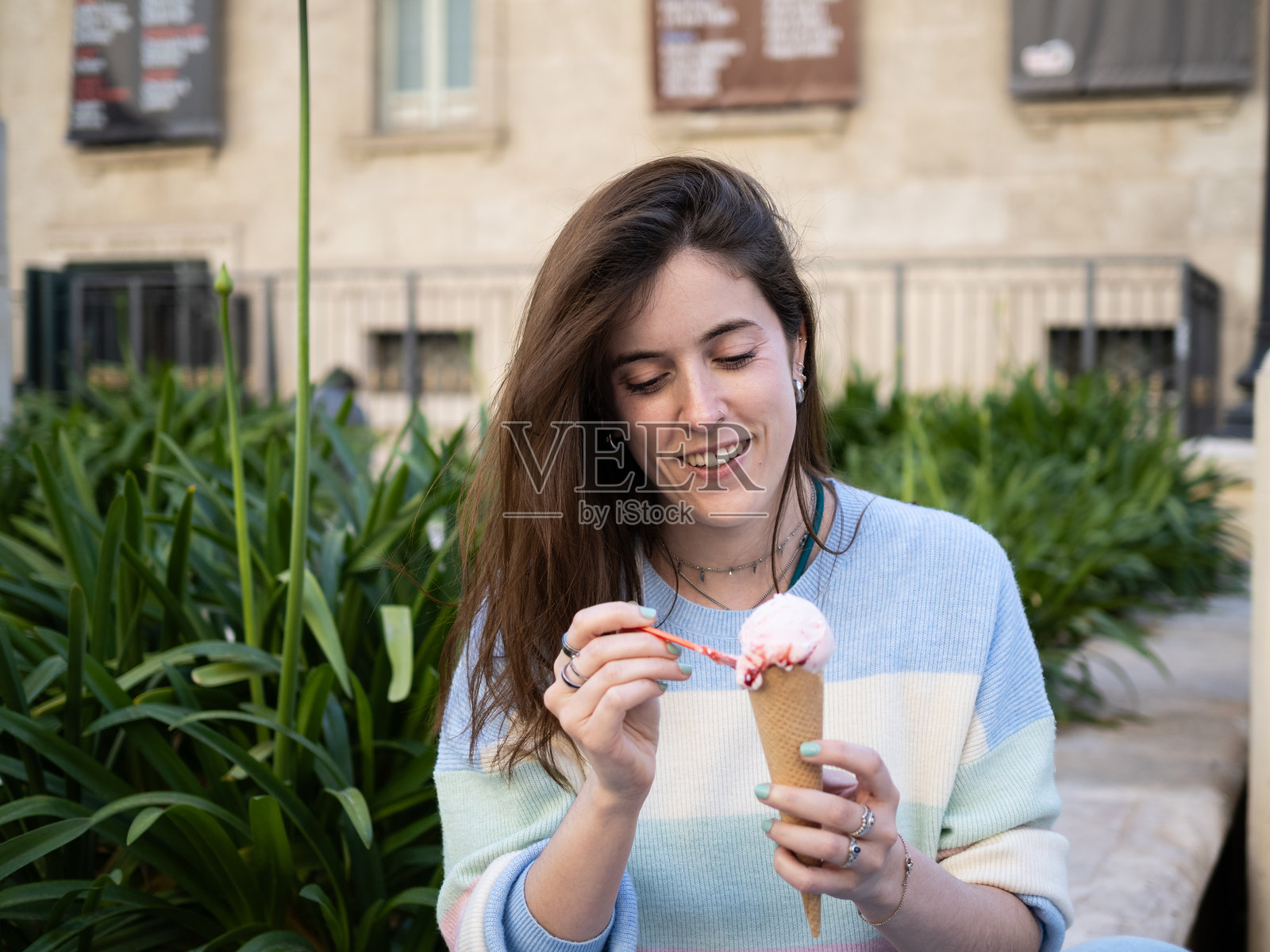 年轻女性在白天的城市公园里享受冰淇淋甜筒照片摄影图片