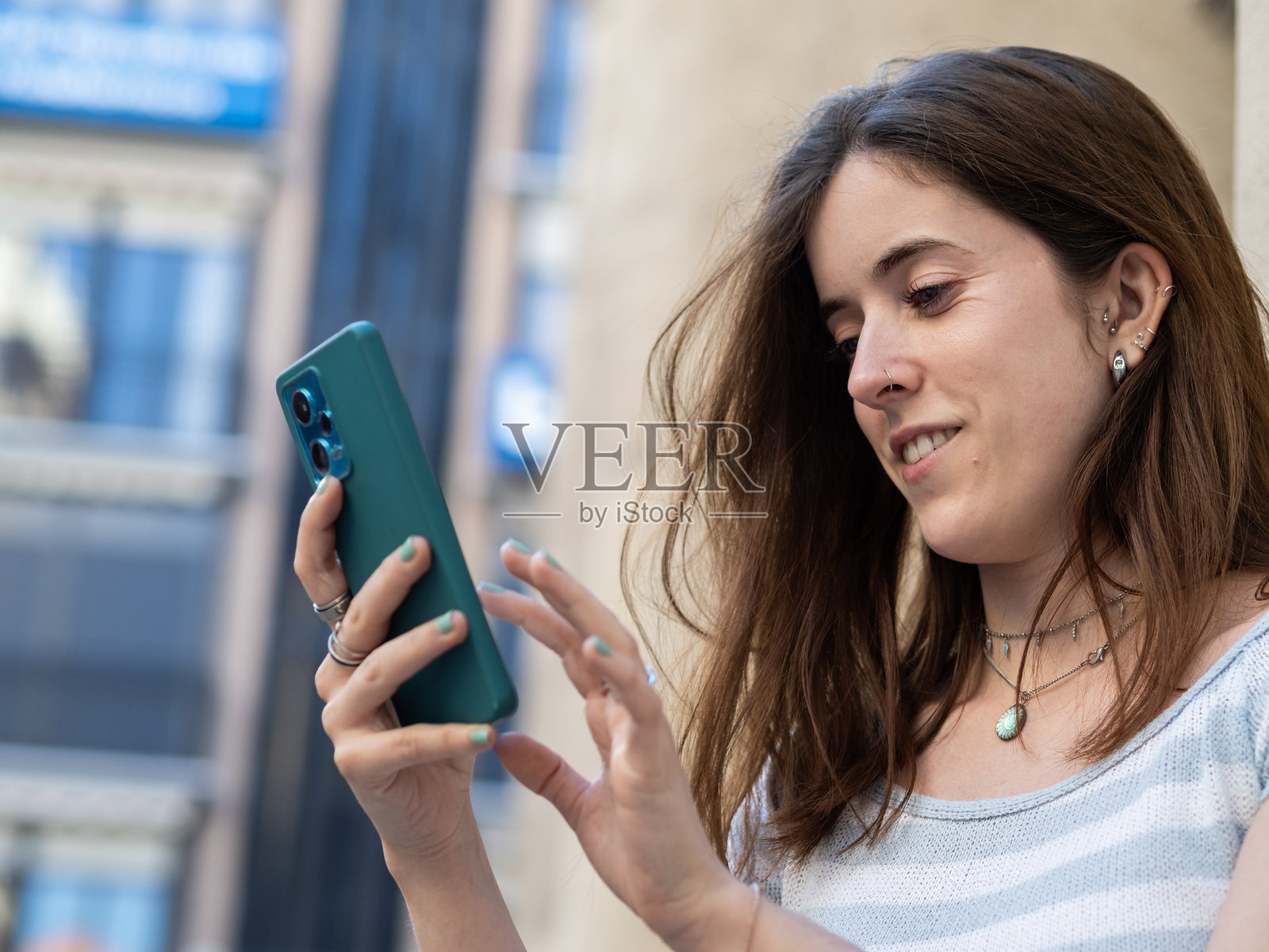 年轻女性在阳光明媚的城市环境中使用智能手机照片摄影图片