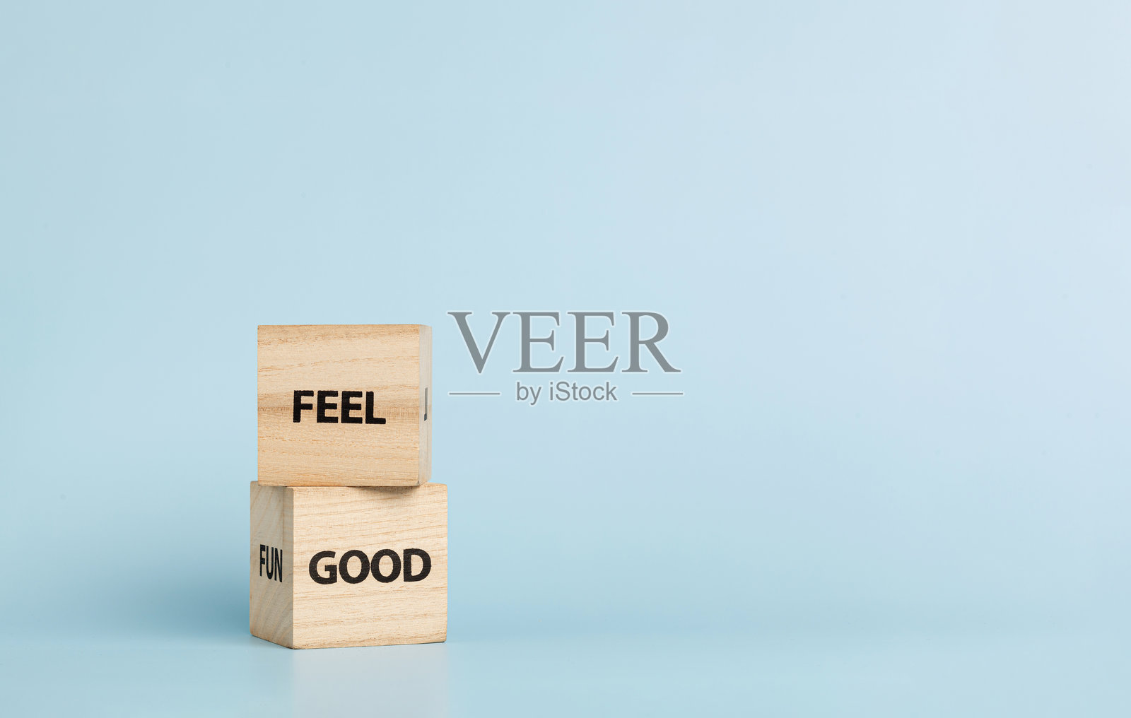 蓝色背景上的木制立方体，上面刻有“Feel Good”字样照片摄影图片
