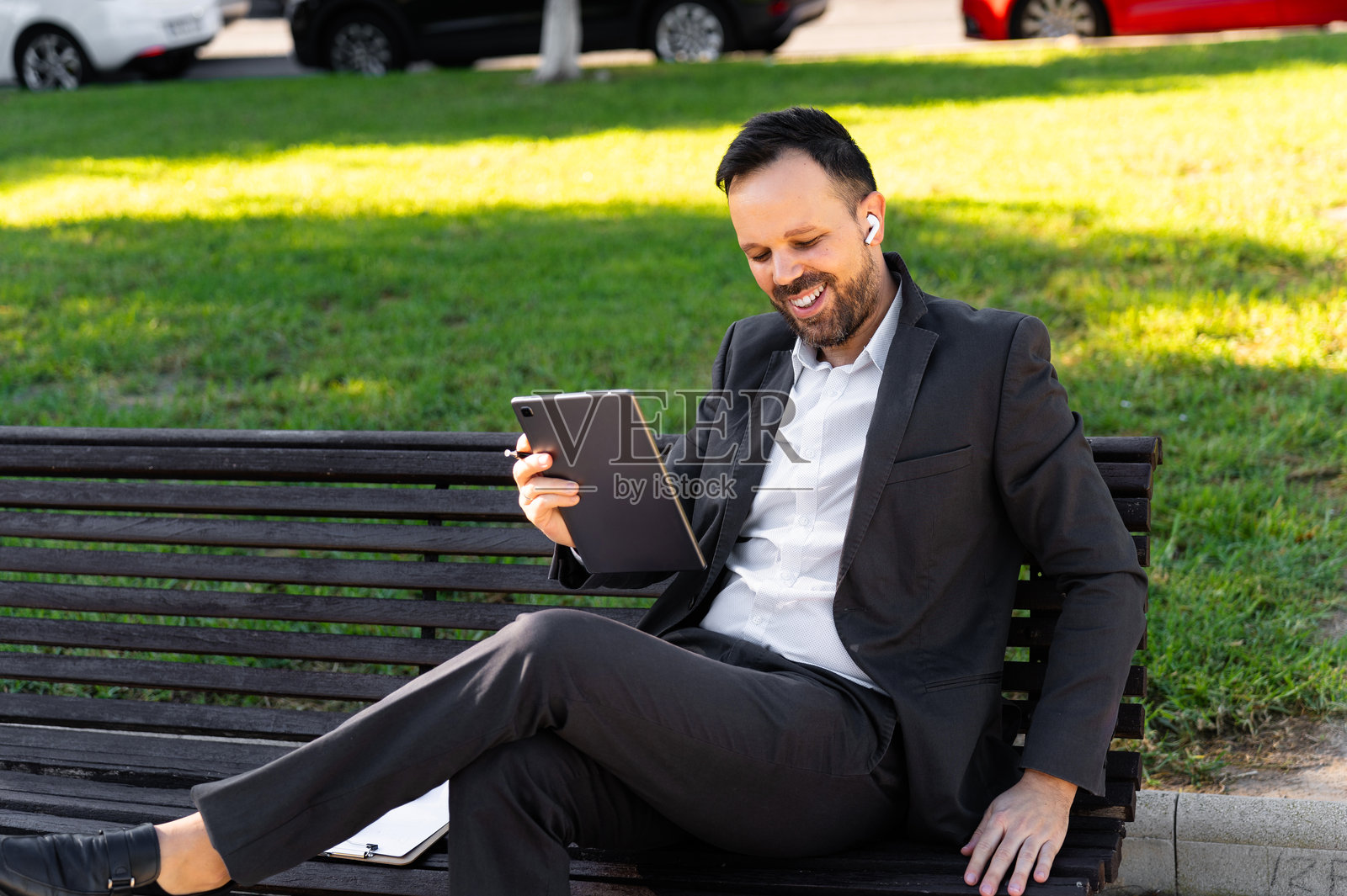 一位40岁以上的商人戴着耳机，通过平板电脑进行视频通话照片摄影图片