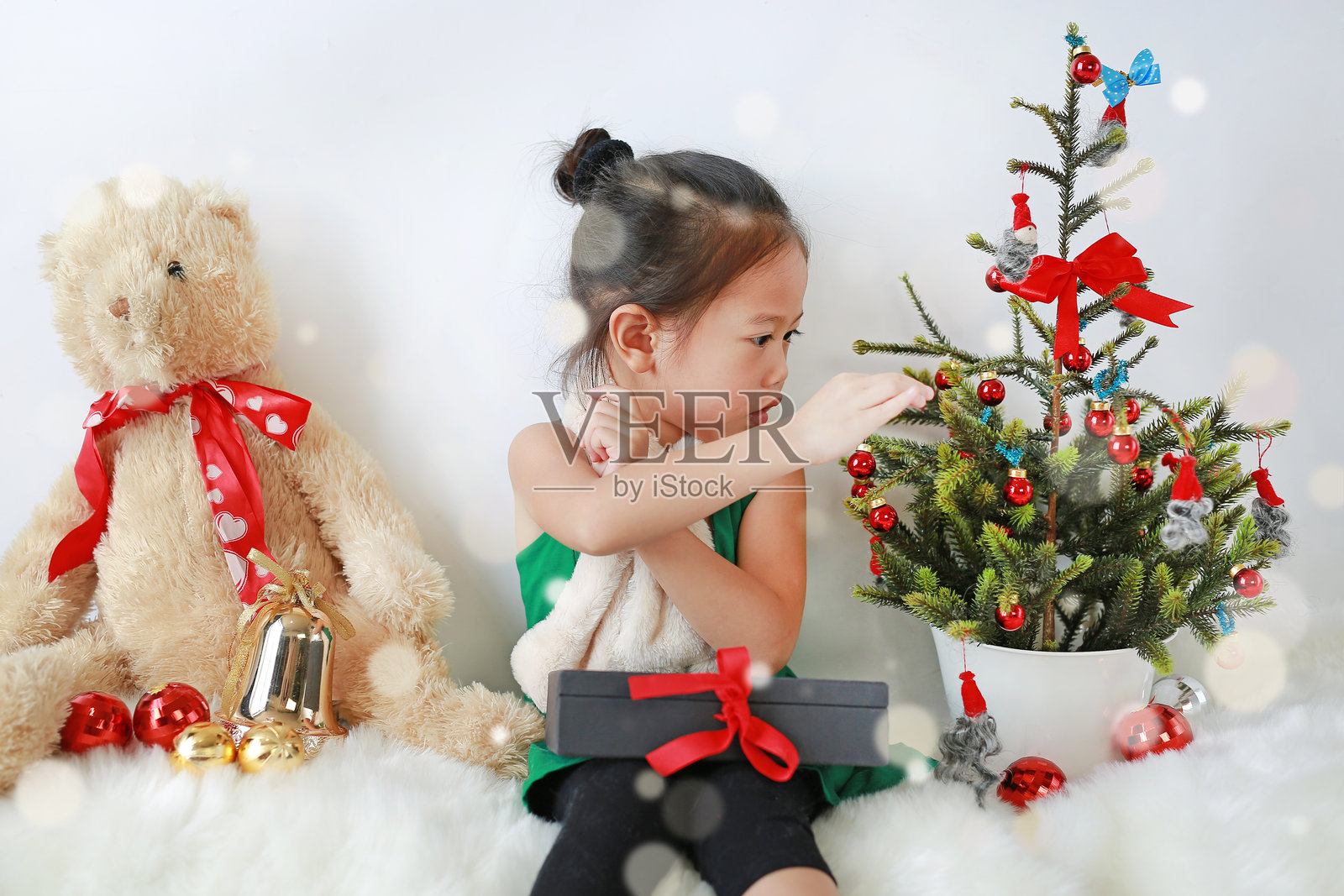 可爱的小女孩穿着圣诞服装，背景为白色。照片摄影图片