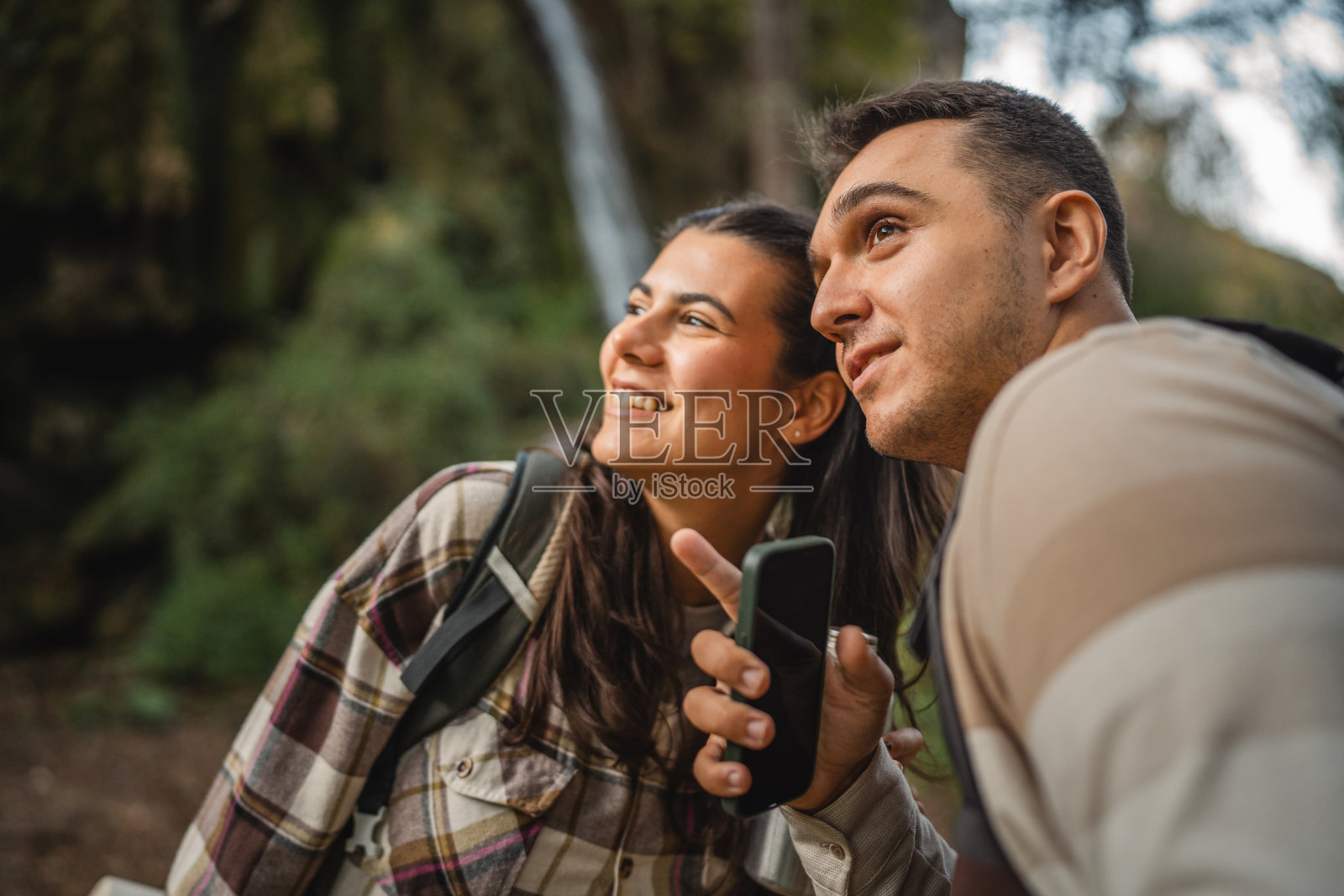 徒步旅行的情侣背包客在森林中探险，并在手机上寻找路线照片摄影图片