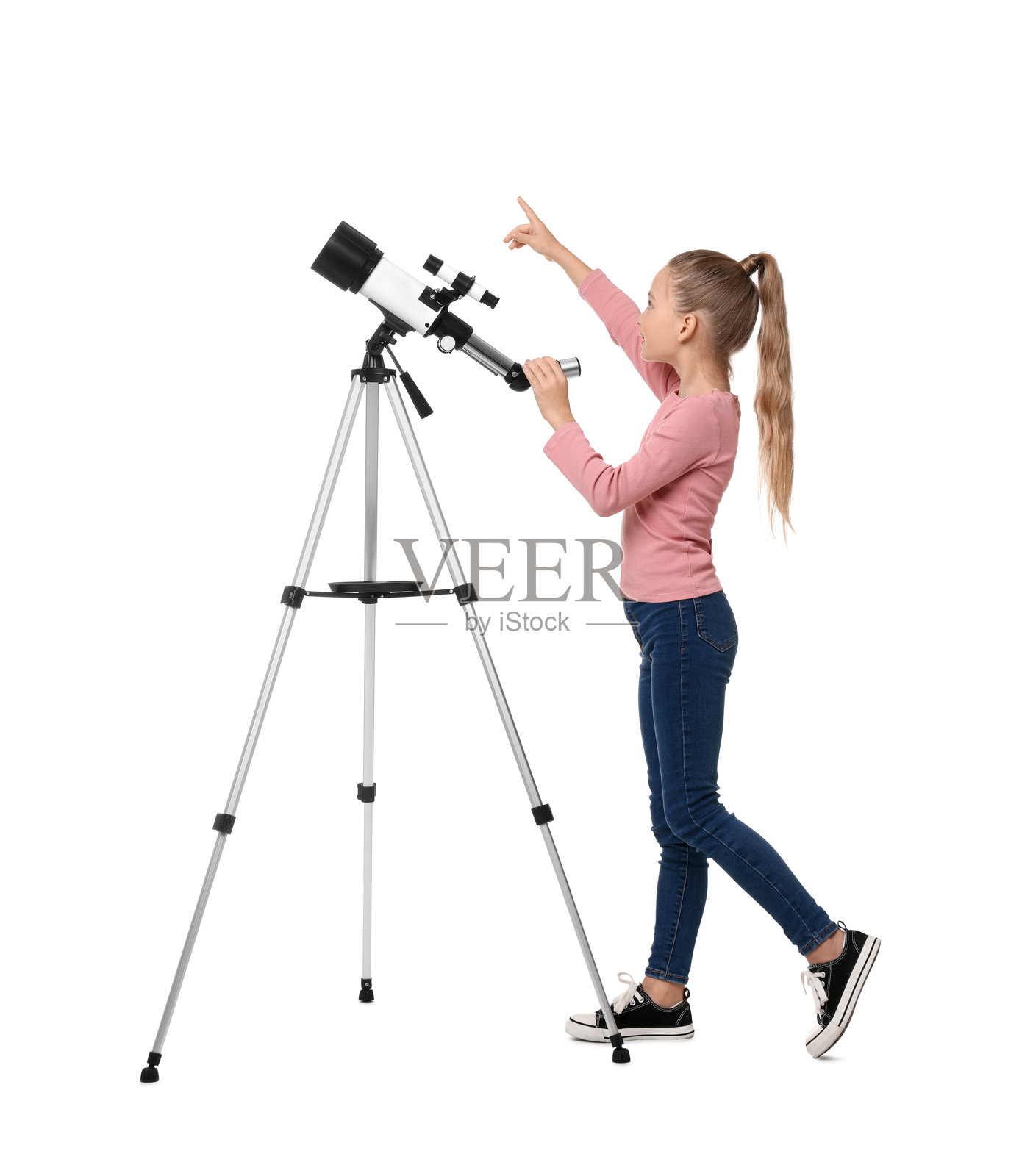 快乐的小女孩用望远镜指向白色背景上的某个东西照片摄影图片