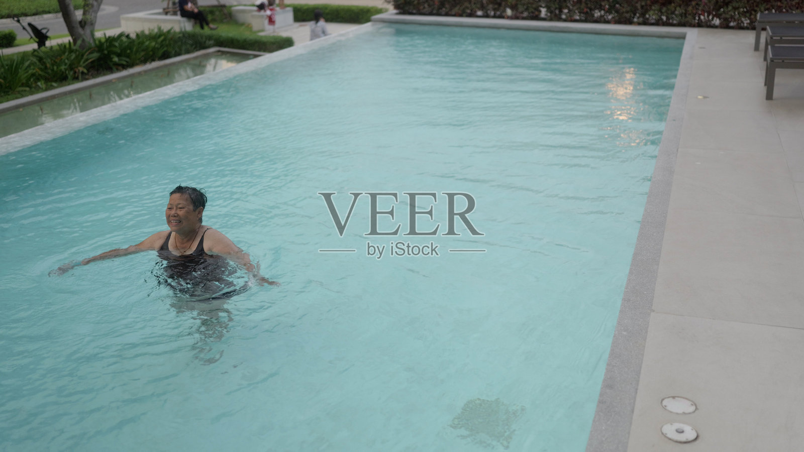 亚洲老年女性在游泳池中进行锻炼。照片摄影图片