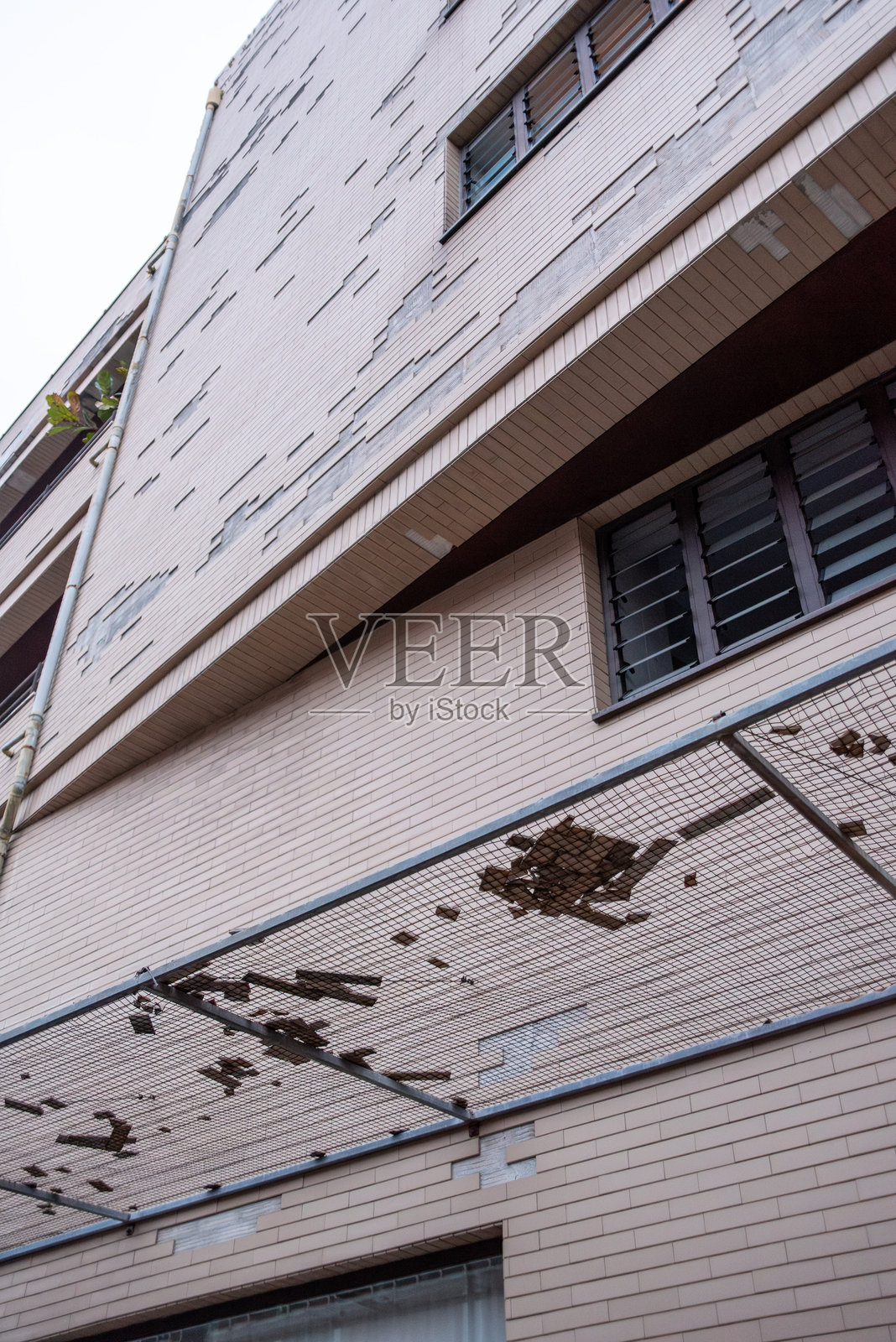 从波尔图一座住宅摩天大楼掉落的瓷砖，仅由网子固定。照片摄影图片