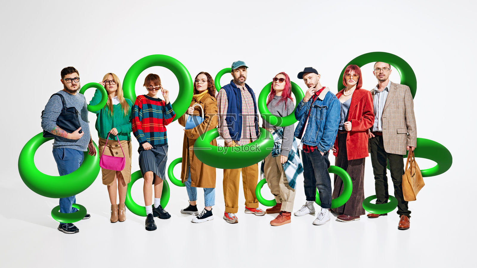 时尚的人们在购物狂欢后摆姿势，手中提着购物袋，背景由绿色未来感的环形图案突出。创意多彩的拼贴画。照片摄影图片