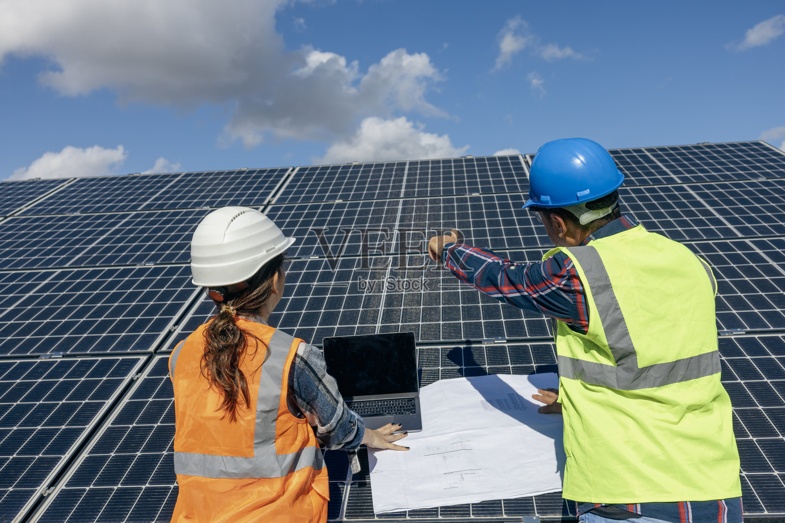 工程师和工人在农场上安装太阳能电池板，致力于清洁电力。照片摄影图片