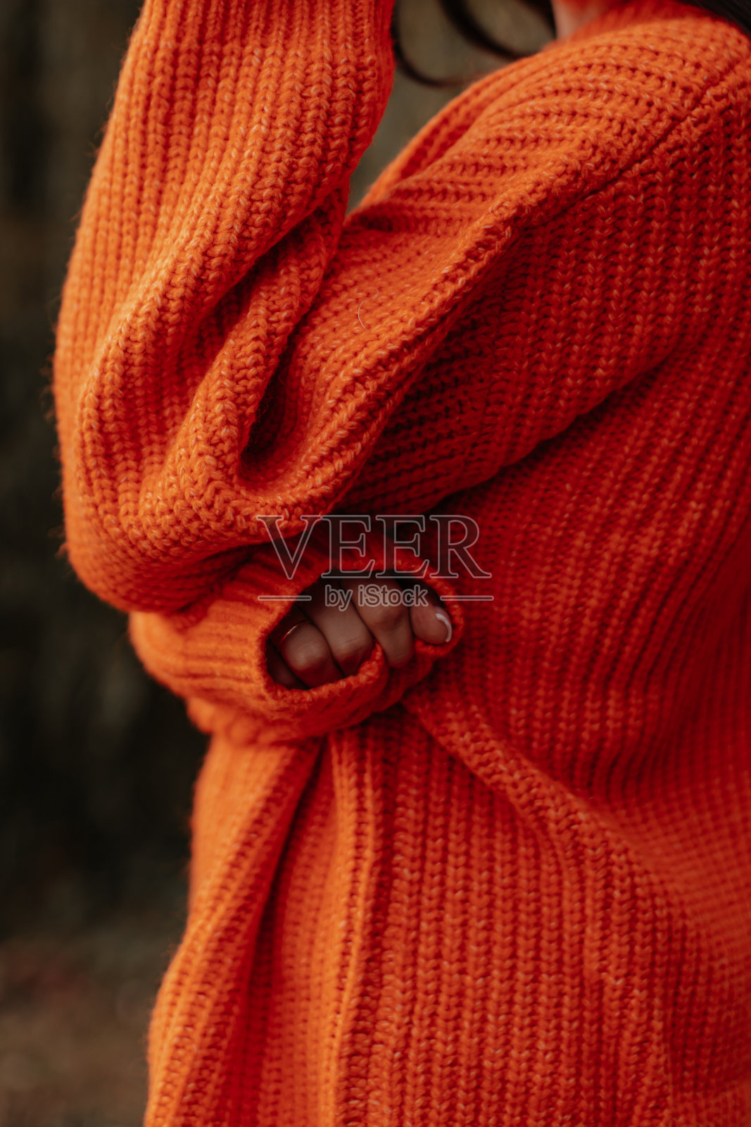 女性身穿亮橙色针织毛衣的秋季服装时尚细节照片摄影图片