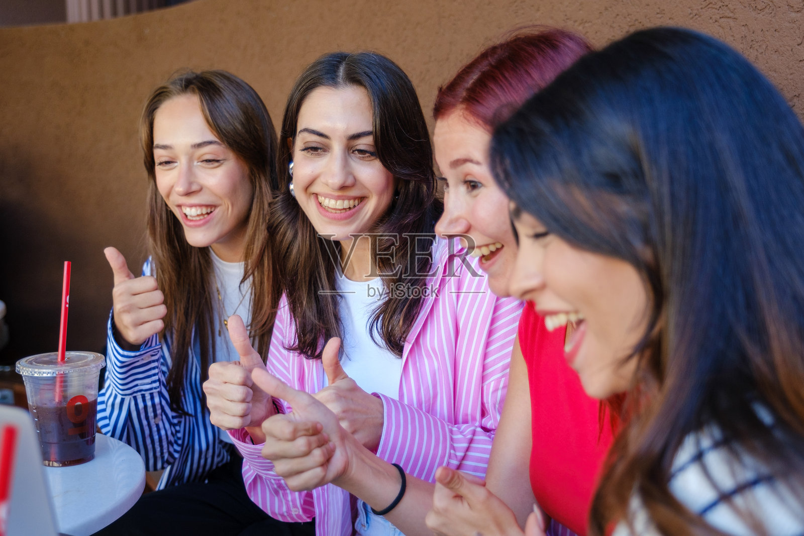 一群年轻女性朋友在咖啡馆里一起快乐地使用笔记本电脑。照片摄影图片