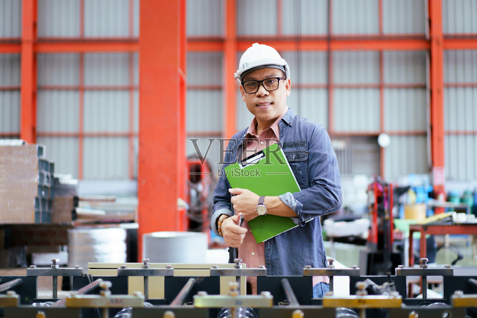 高级工业或机械工程师正在对机器进行检查。照片摄影图片