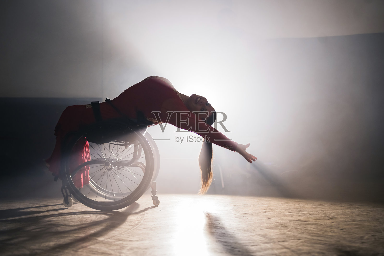 轮椅上的女性在舞厅中训练时跳舞、旋转、旋转。照片摄影图片