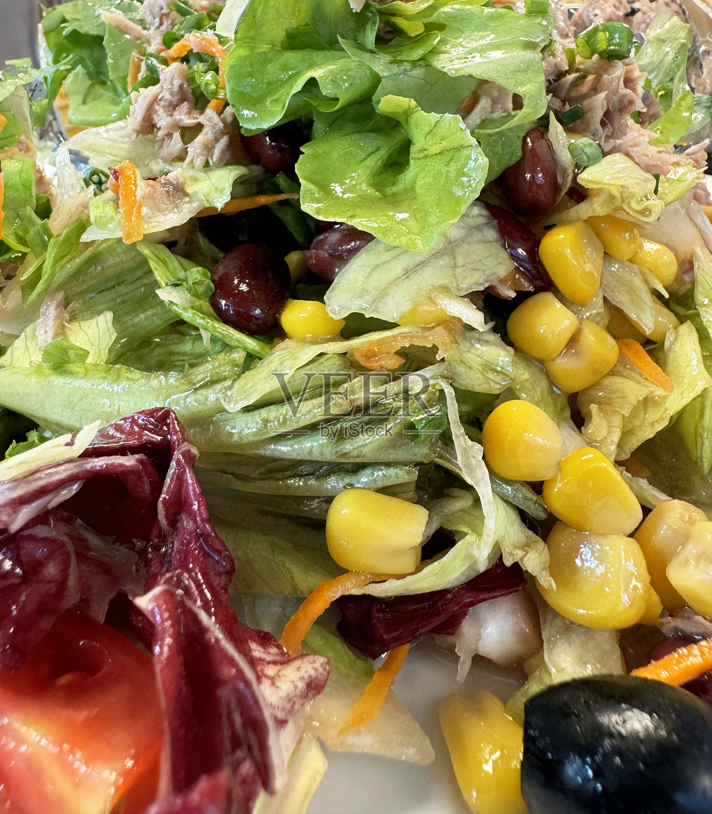 新鲜多彩的沙拉，包含生菜、玉米、西红柿和豆类，特写生动。照片摄影图片