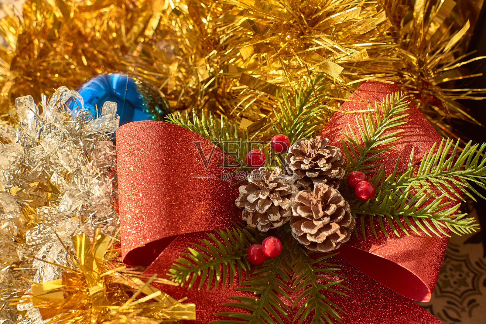 节日的圣诞装饰：蓝色饰品、松 cones 和红色蝴蝶结照片摄影图片