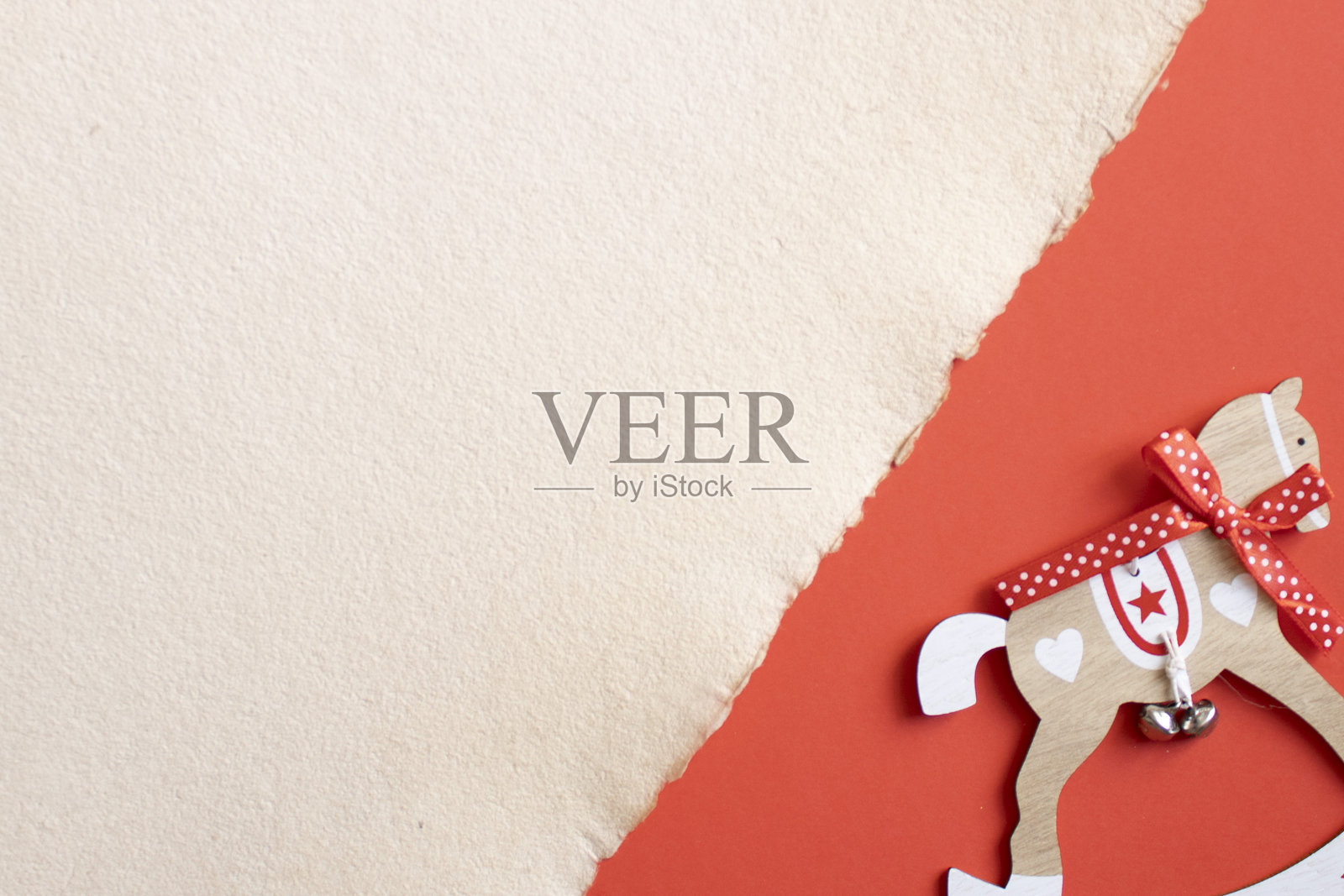 红色纸背景上的木马装饰品照片摄影图片