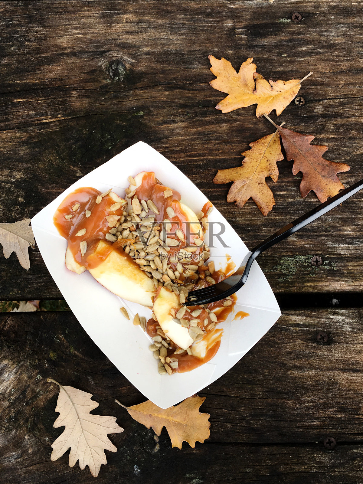 切片苹果配焦糖和葵花籽装饰照片摄影图片