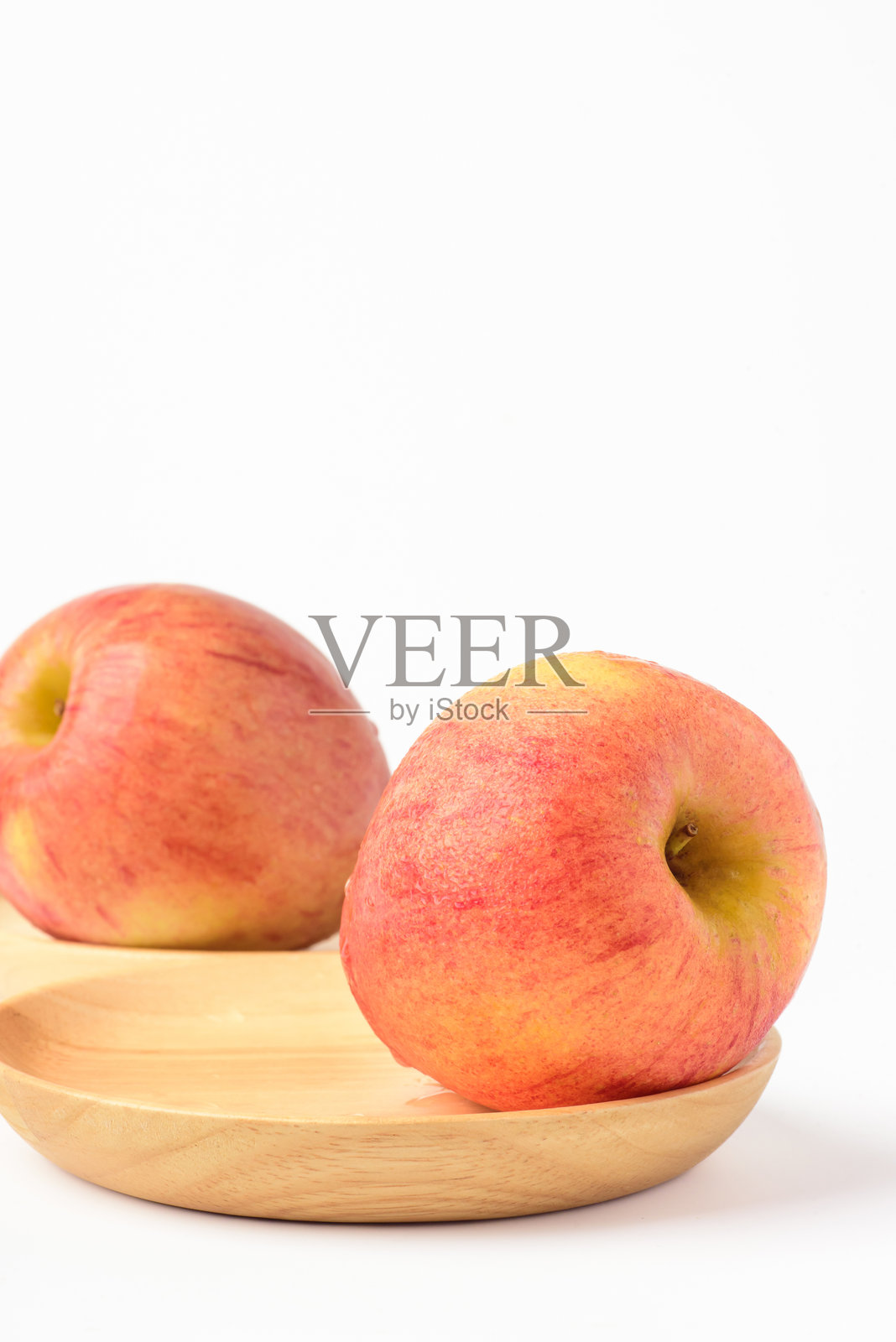 新鲜成熟的苹果上带有细小水珠，背景为白色照片摄影图片