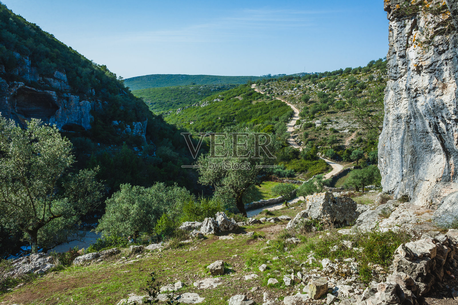卡斯米洛的布拉卡斯，葡萄牙的一处自然景观，岩石悬崖上布满了大型洞穴。这些洞穴坐落在郁郁葱葱的景色中，泥土小径蜿蜒穿过橄榄树和绿色植被。照片摄影图片