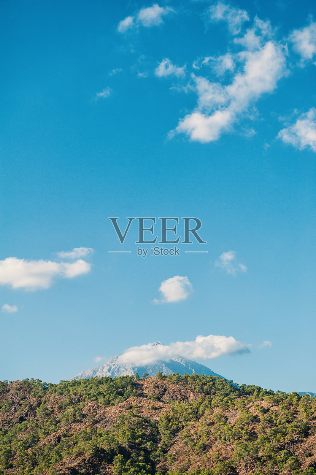 宁静的山峰，点缀着云朵和郁郁葱葱的山丘照片摄影图片