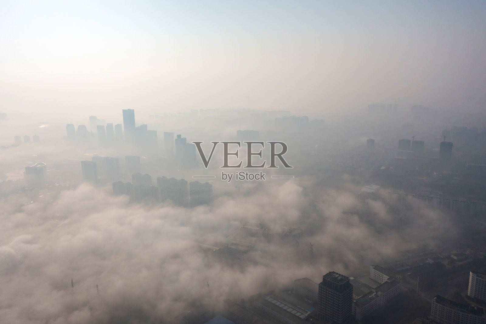 雾中的城市鸟瞰图。摩天大楼高耸于雾之上。照片摄影图片