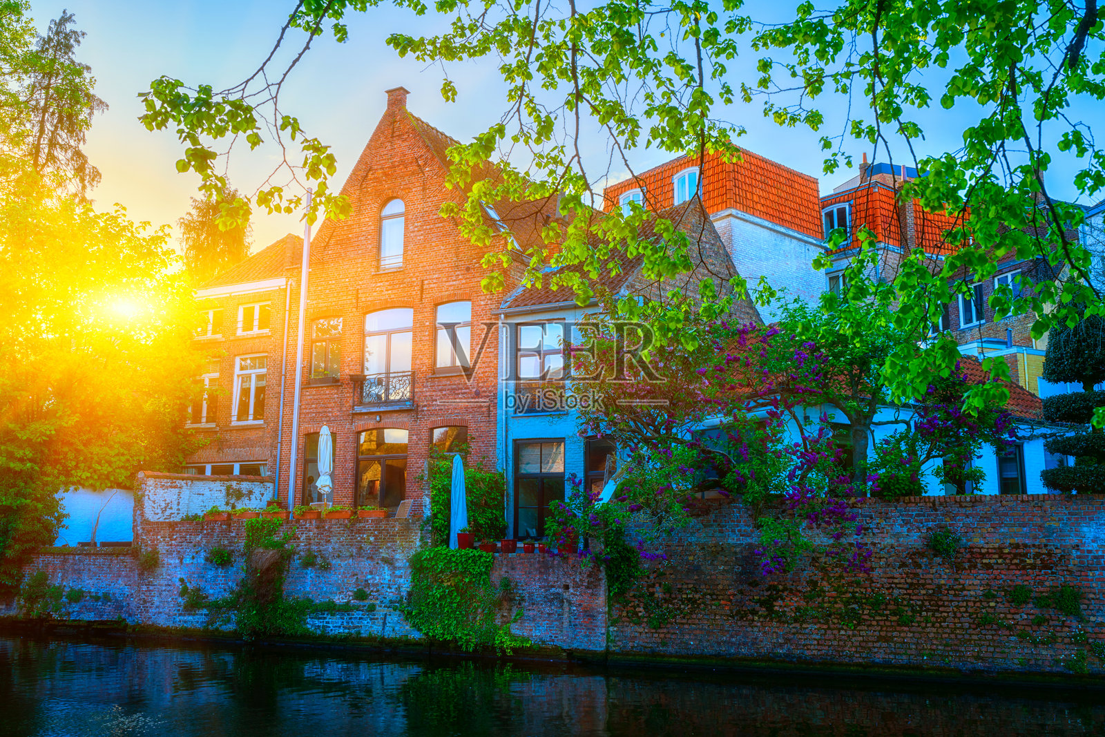 比利时布鲁日老城。日落时分，沿运河的中世纪历史建筑构成的迷人城市风景，旅行背景。照片摄影图片