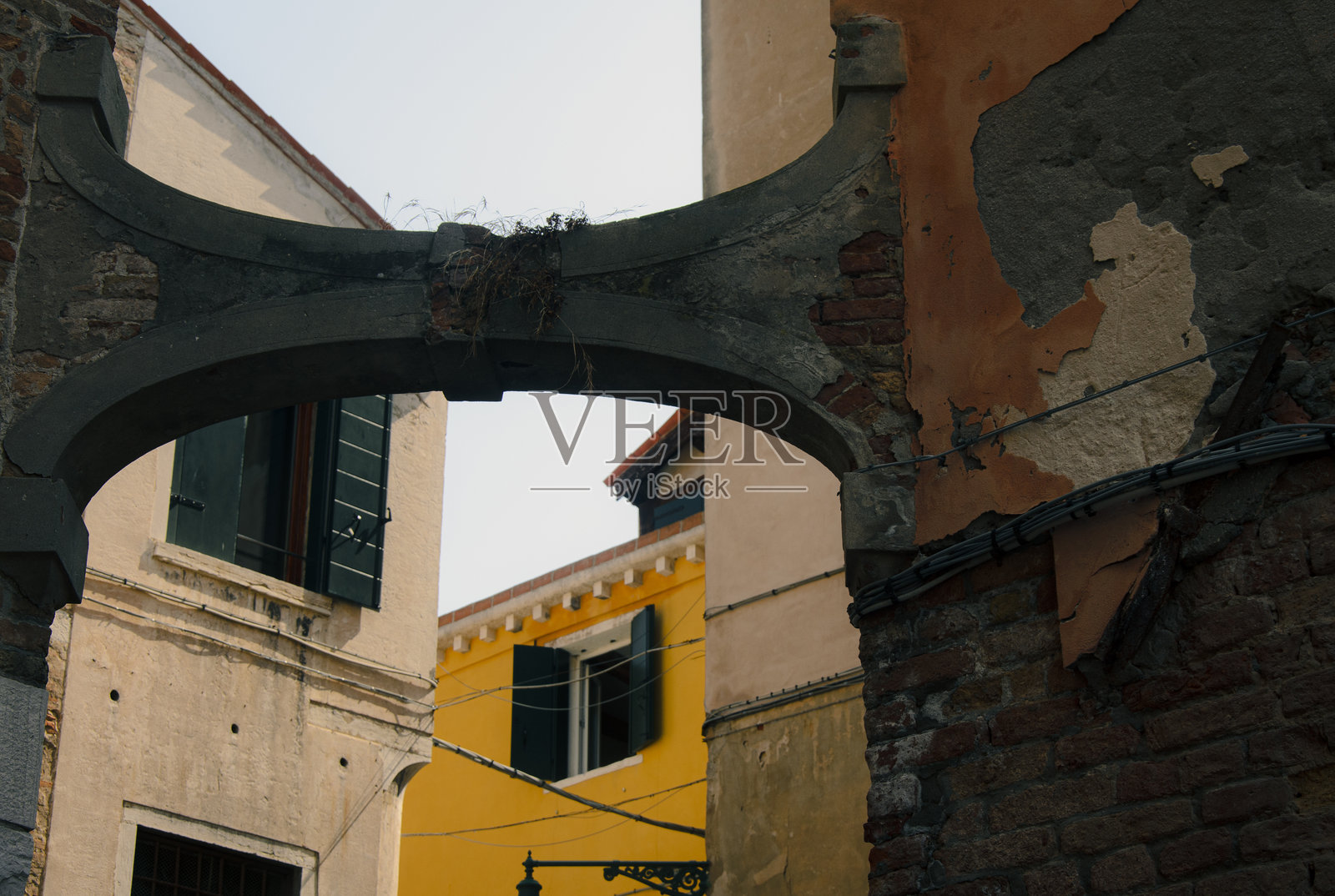 风化的拱门与色彩斑斓的古老建筑在历史悠久的欧洲小镇上照片摄影图片