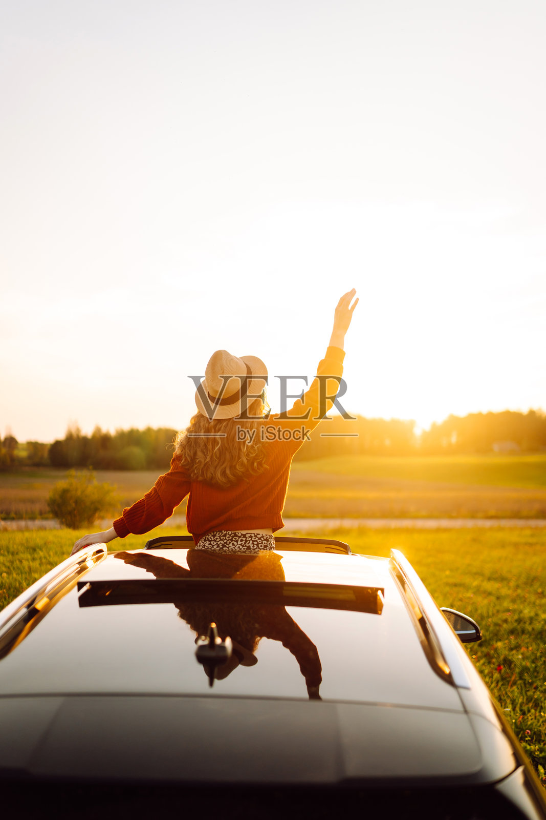 放松的女性在夏季公路旅行中享受窗外风景。照片摄影图片