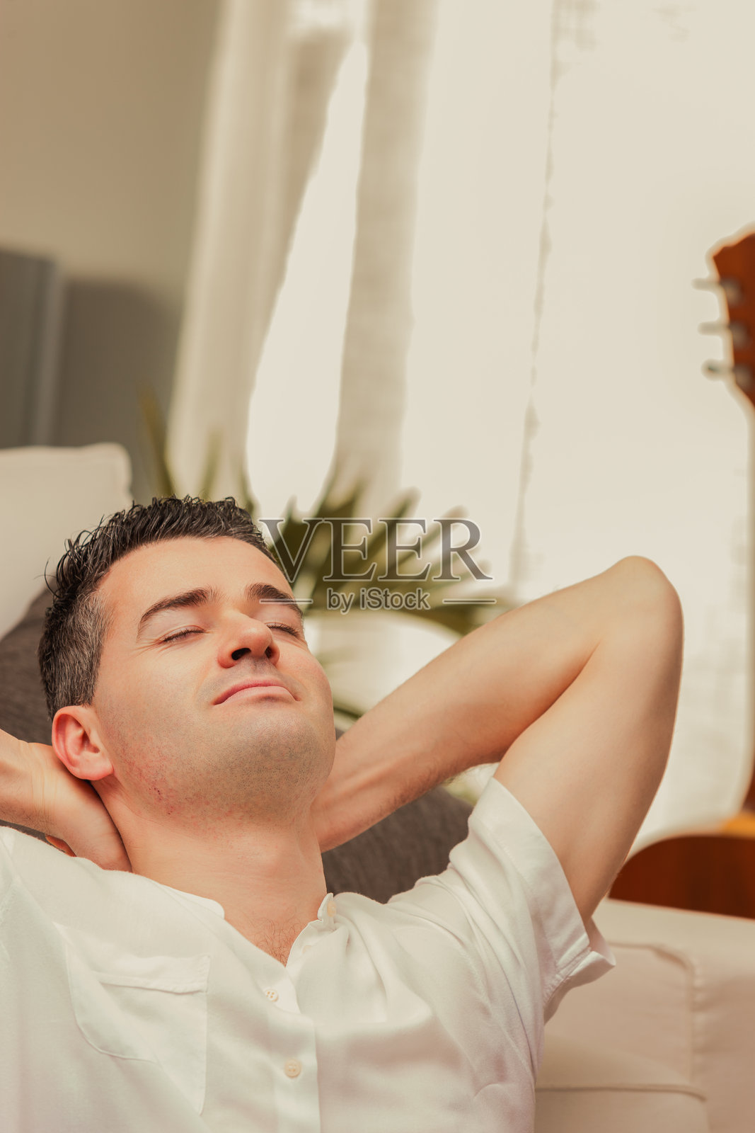 男人在家沙发上放松，闭着眼睛。照片摄影图片