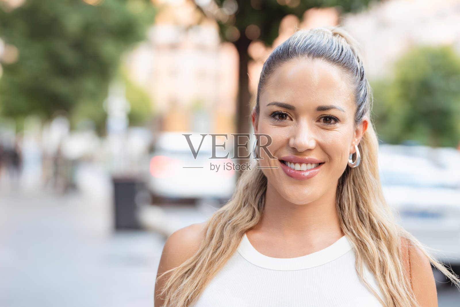 微笑的年轻女性在城市街道上摆姿势照片摄影图片