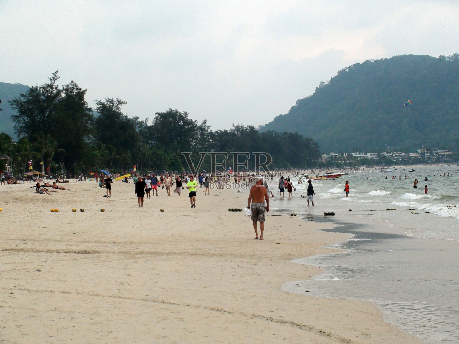 芭东海滩，许多游客坐着、走动和游泳。普吉岛，泰国，亚洲。照片摄影图片