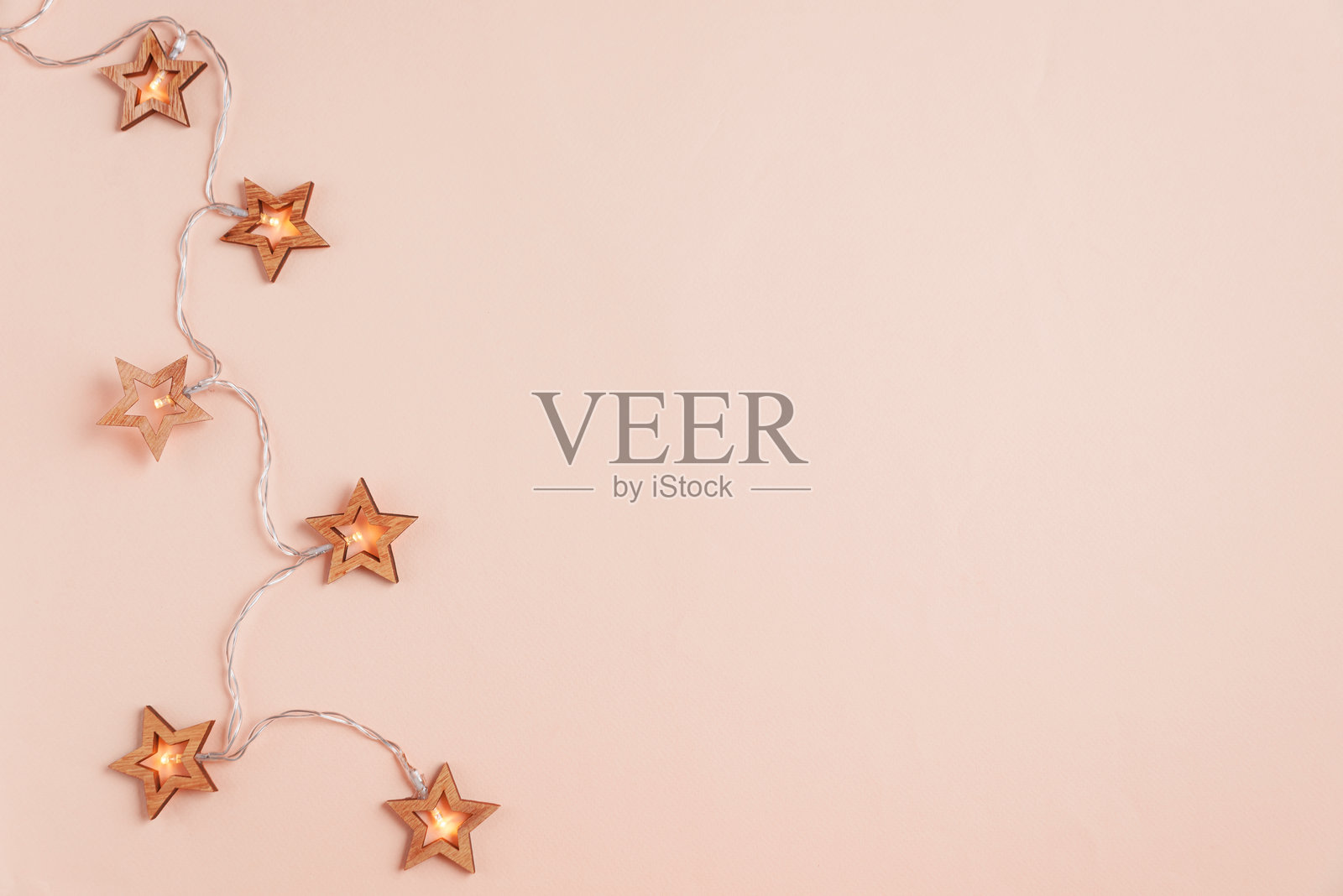 粉色背景上的圣诞假期背景，装饰有圣诞灯光。俯视图。照片摄影图片