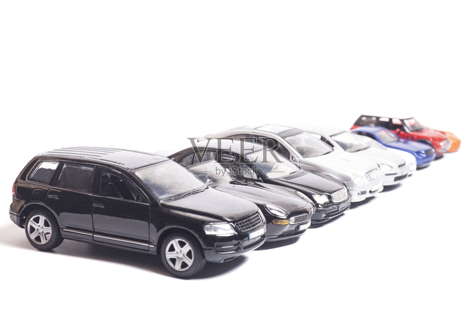 一排停放在白色背景上的玩具车照片摄影图片