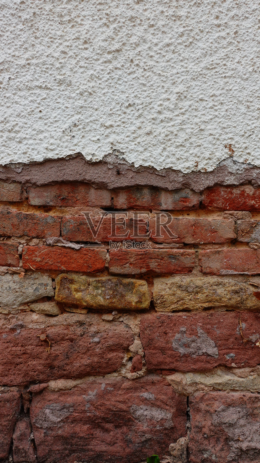 一面陈旧的砖墙，展示出红色和米色的层次。照片摄影图片