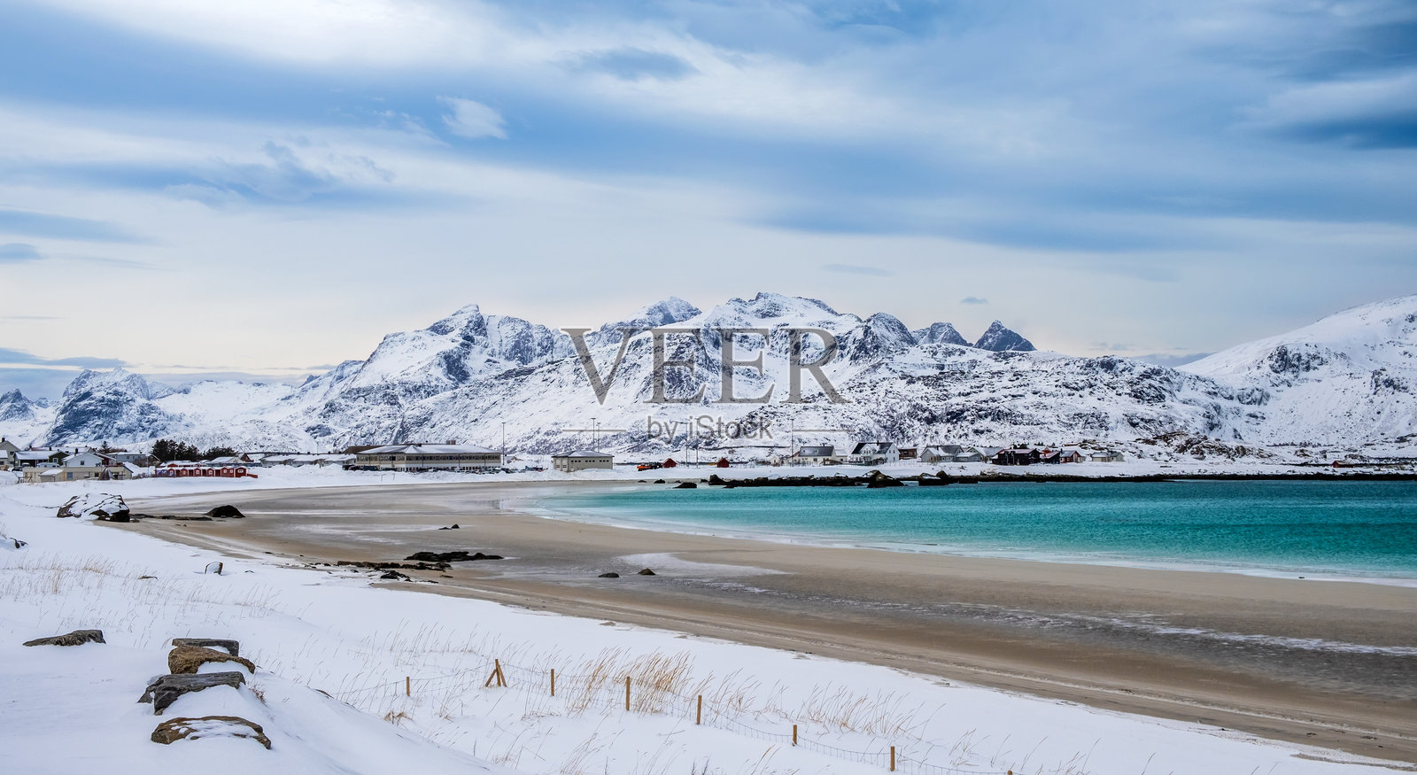 挪威洛福滕群岛的拉姆贝格海滩（Rambergstranda）冬季景色，雪山、北方沙滩和清澈的挪威海水构成的冬季风光。照片摄影图片