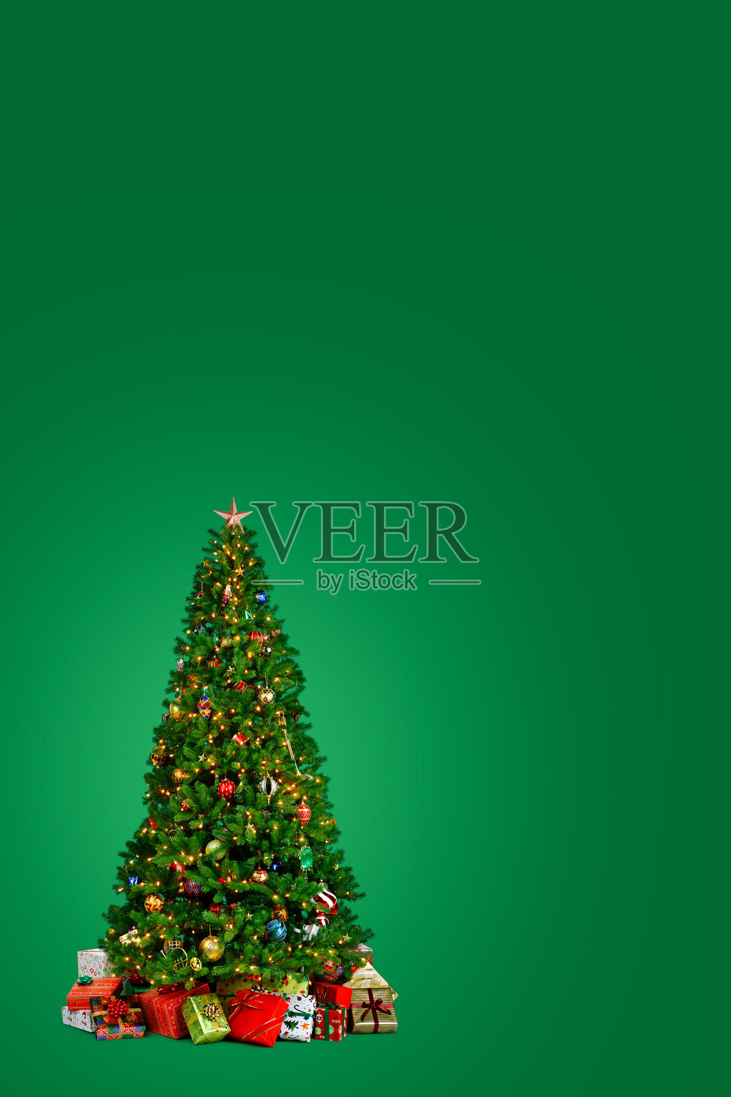 绿色背景上的圣诞树与礼物环绕在一起照片摄影图片